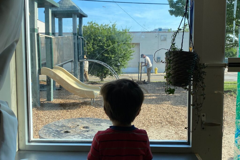 Child watches the work crew install new equipment.