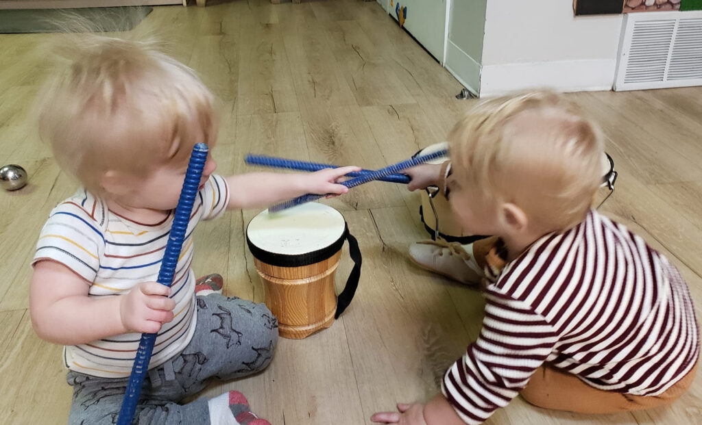 Infants play with drums