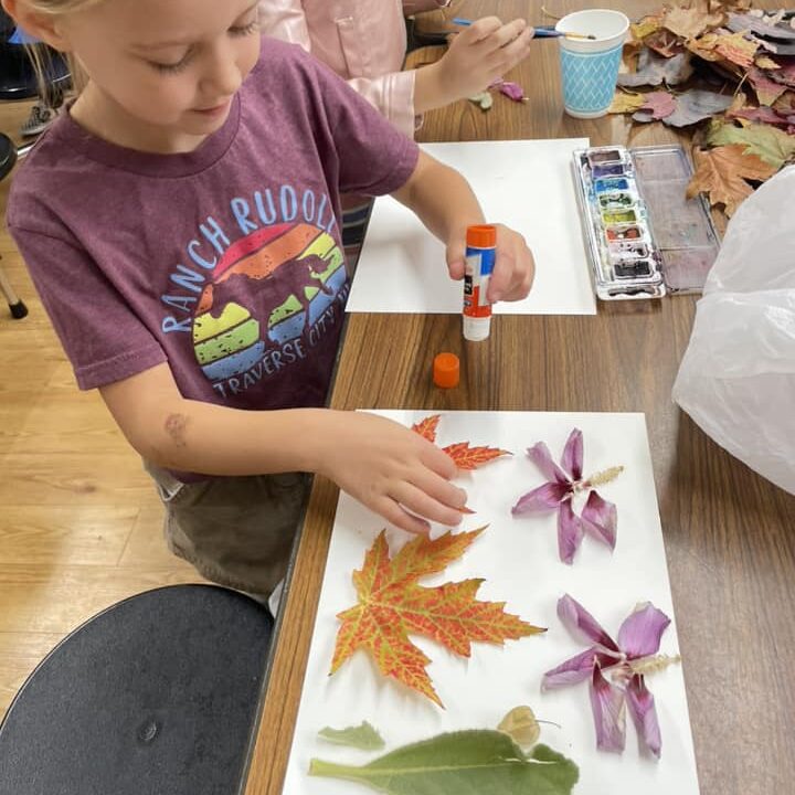 Mara crafts with fall leaves.