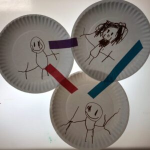A small family tree made from taped together plates, each featuring a family member.
