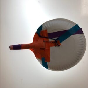 A shaking drub made from a paper plate with handle.