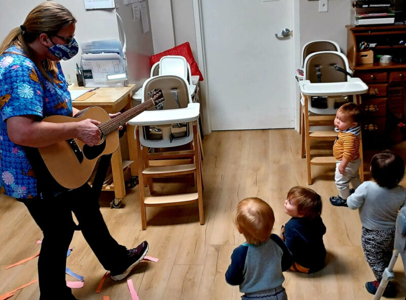 Penny playing guitar to the Tesoro infants.